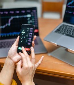 Woman checking chart for currency information on laptop. Cryptocurrency concept