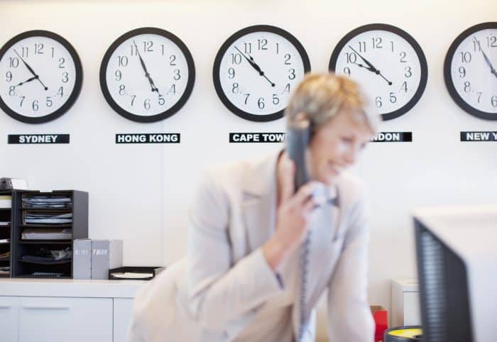 World clocks behind businesswoman in office