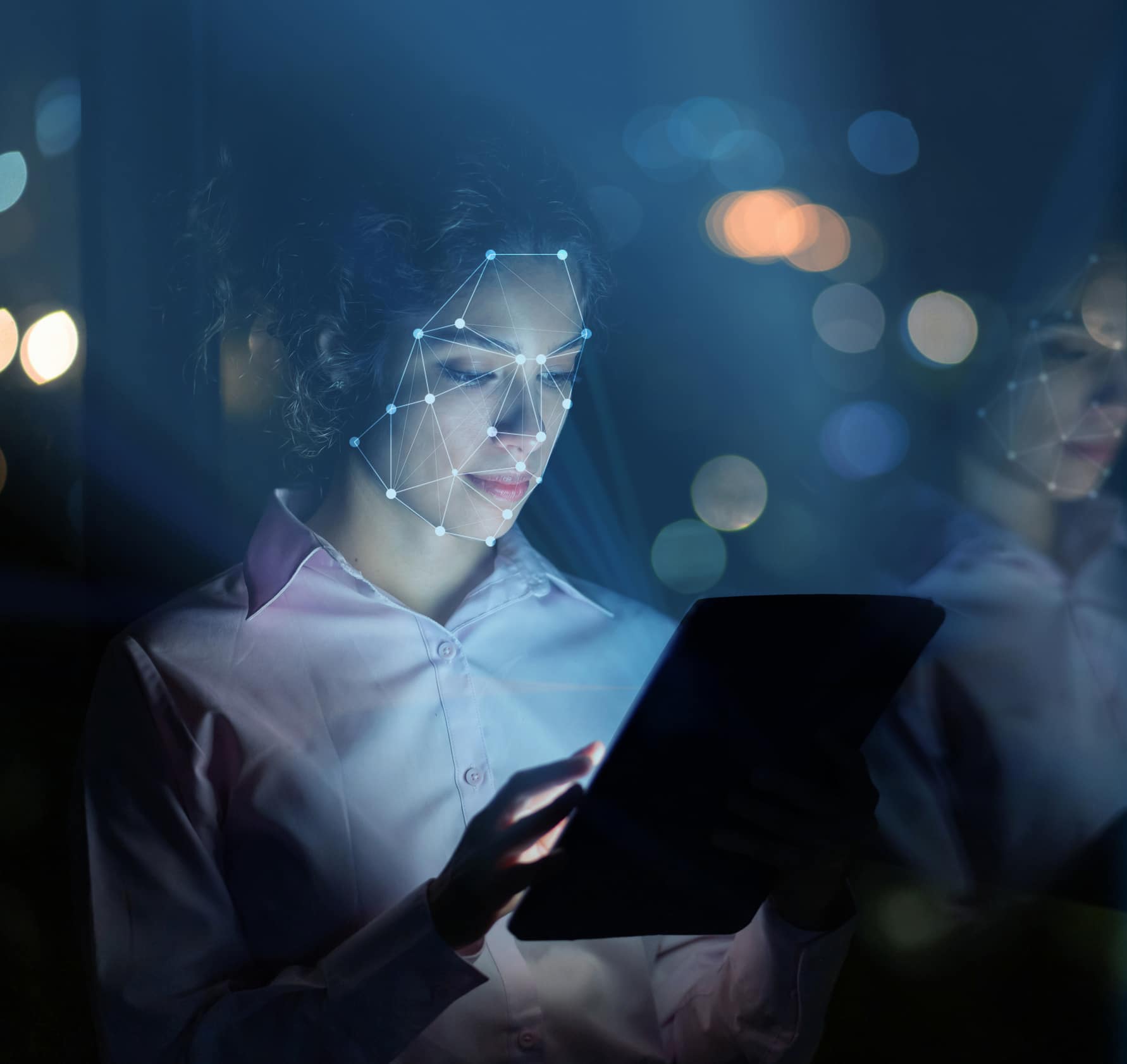 Woman using facial recognition technology to access her tablet computer